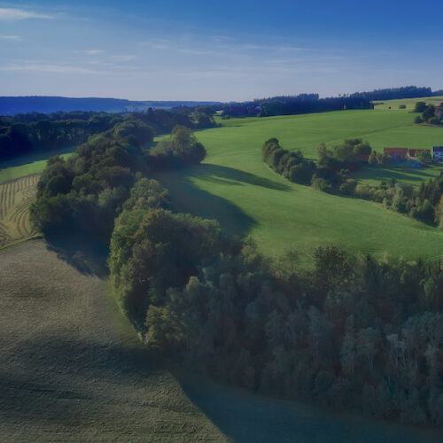 Amazing spring landscape with green rolling hills and farmhouses in the heart of Germany, before sunset